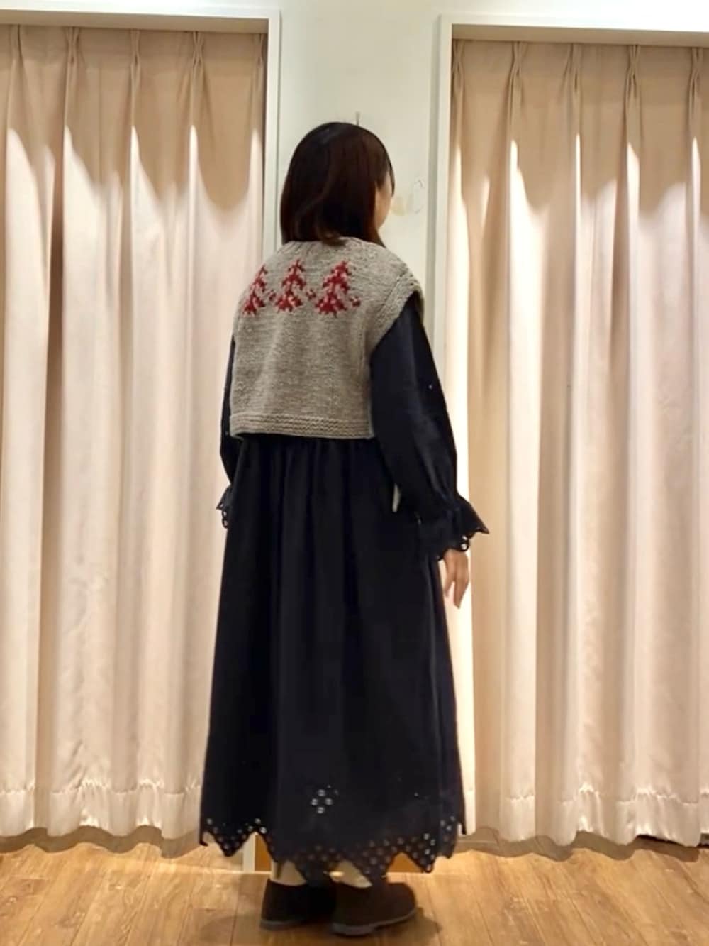 グレー系のベスト、ブラウン系のドレスシューズ、ブラック系のワンピース/ドレスを着用したレディースの秋コーディネートの2枚目の写真