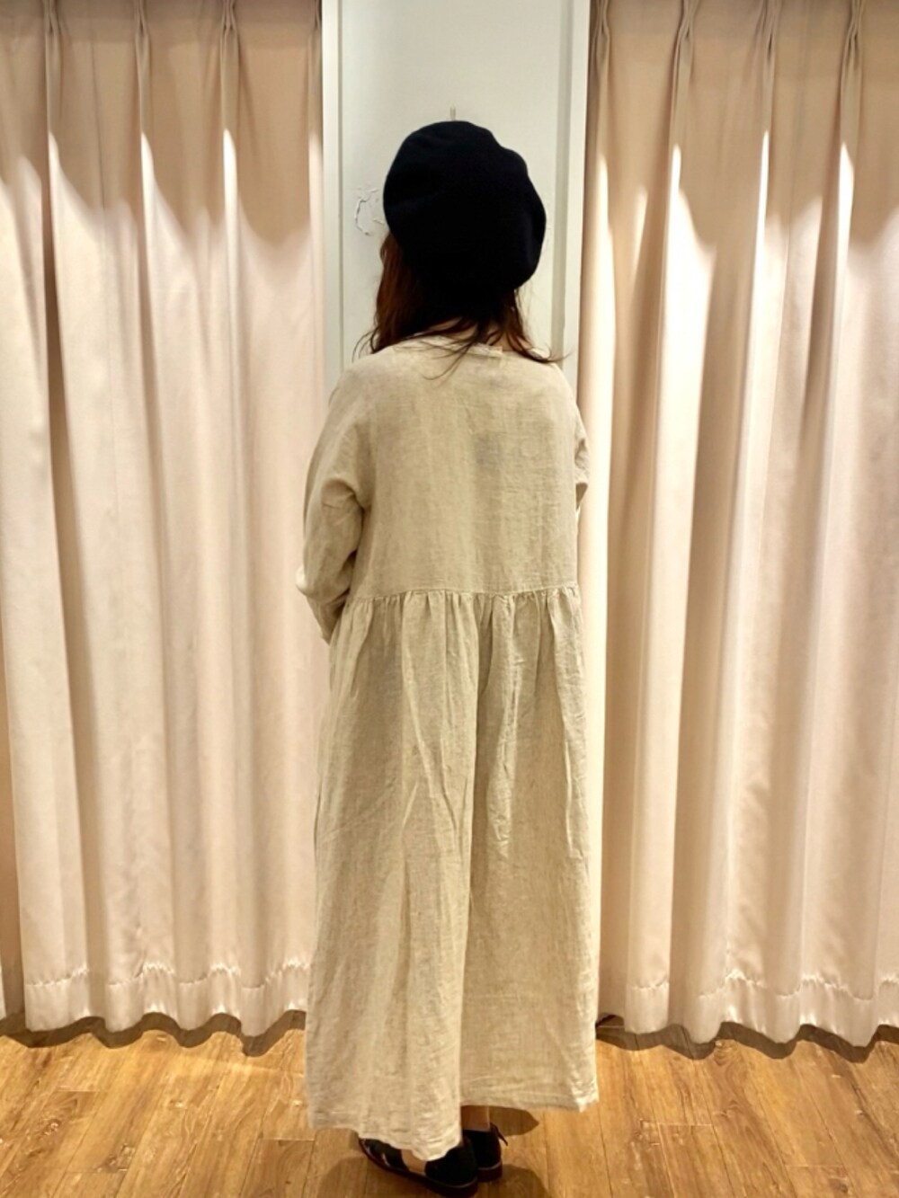 ベージュ系のワンピース、ブラック系のハンドバッグ、ブラック系のサンダルを着用したレディースの夏コーディネートの2枚目の写真