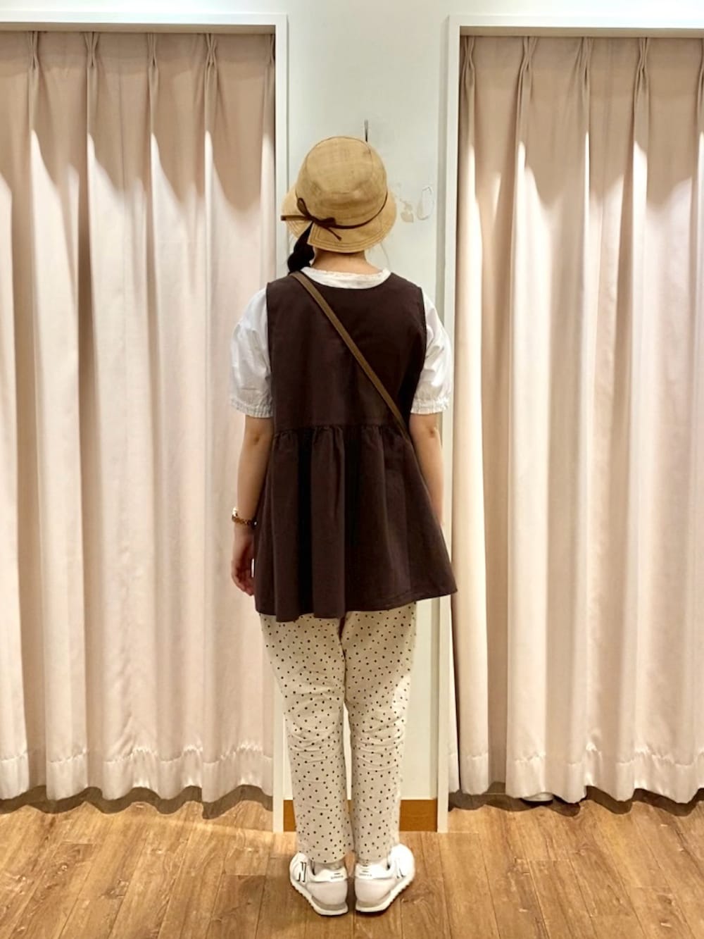 ホワイト系のシャツ/ブラウス、ブラウン系のベスト、ホワイト系のハンドバッグを着用したレディースの夏コーディネートの2枚目の写真