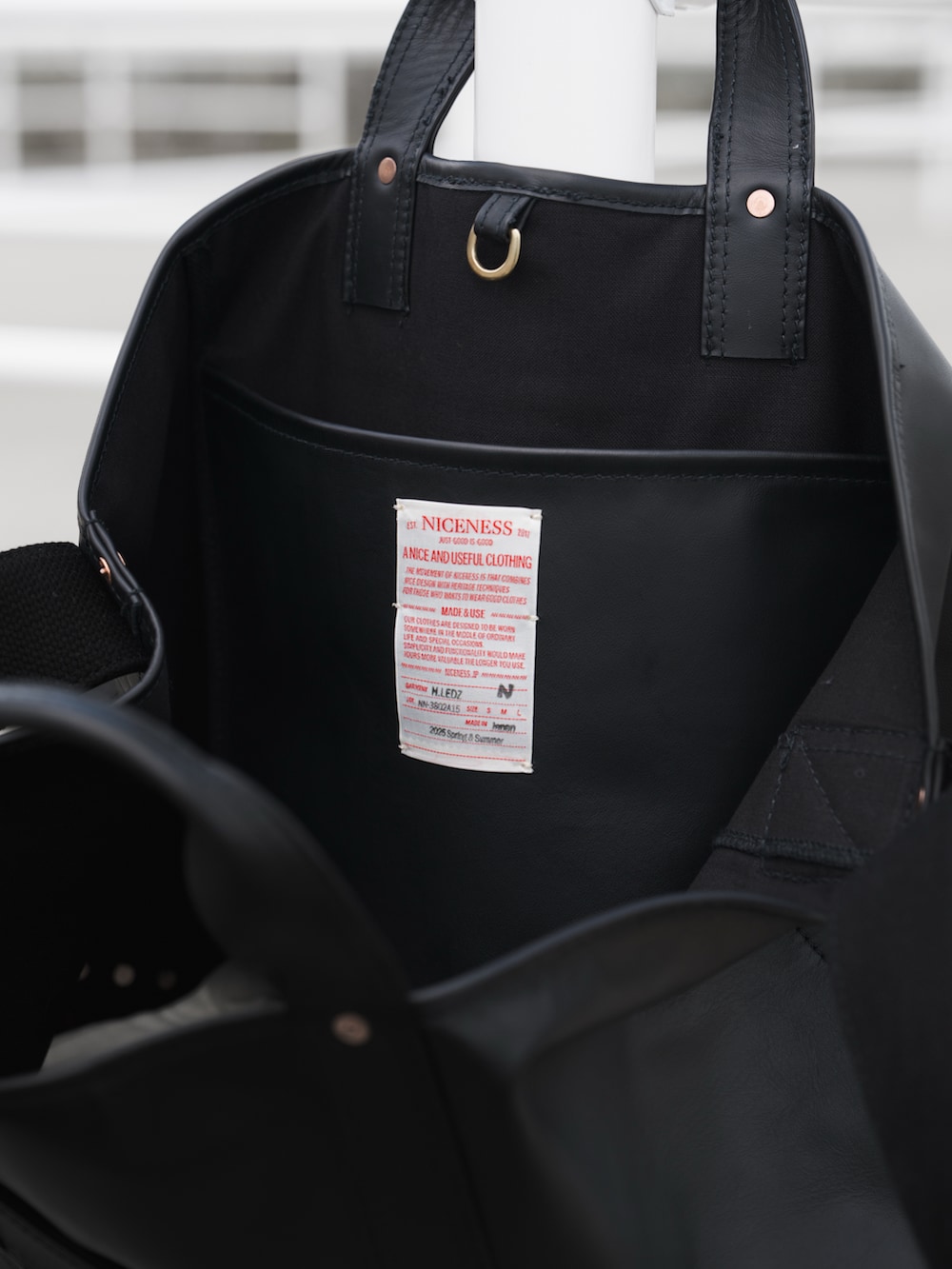 グレー系のシャツ/ブラウス、ブラック系のトートバッグ、ブラウン系のローファーを着用したメンズの春コーディネートの5枚目の写真