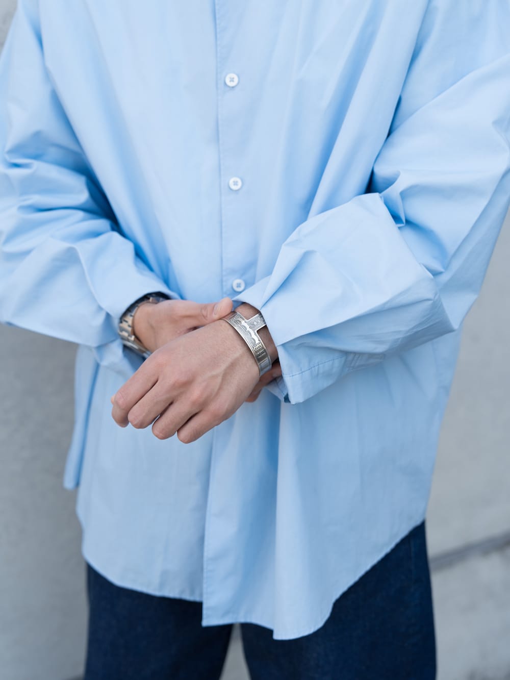 ブルー系のデニムパンツ、ホワイト系のスニーカー、ブルー系のシャツ/ブラウスを着用したメンズの春コーディネートの4枚目の写真