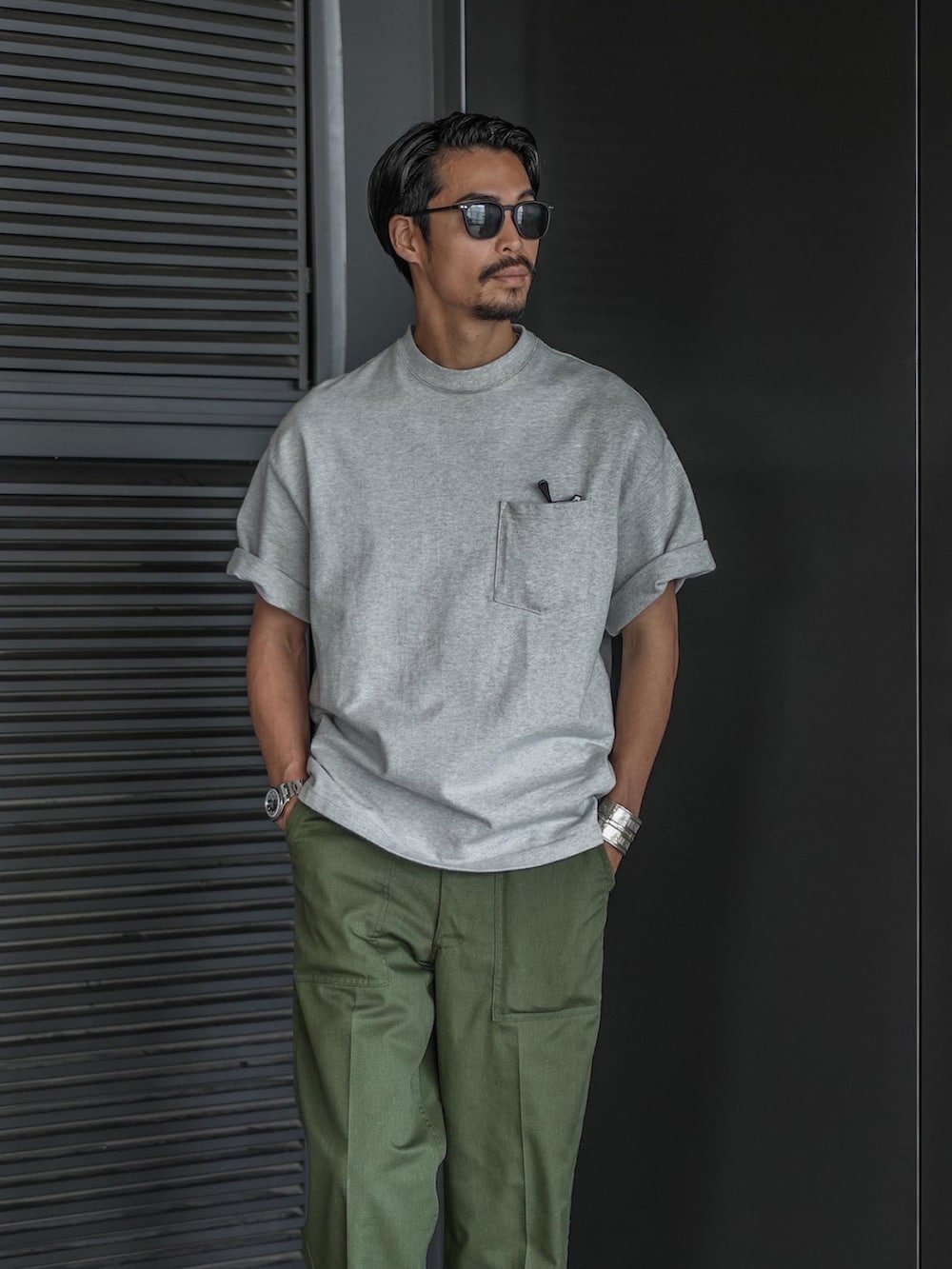 ホワイト系のTシャツ/カットソー、グリーン系のチノパンツ、ブラック系のローファーを着用したメンズの夏コーディネートの2枚目の写真