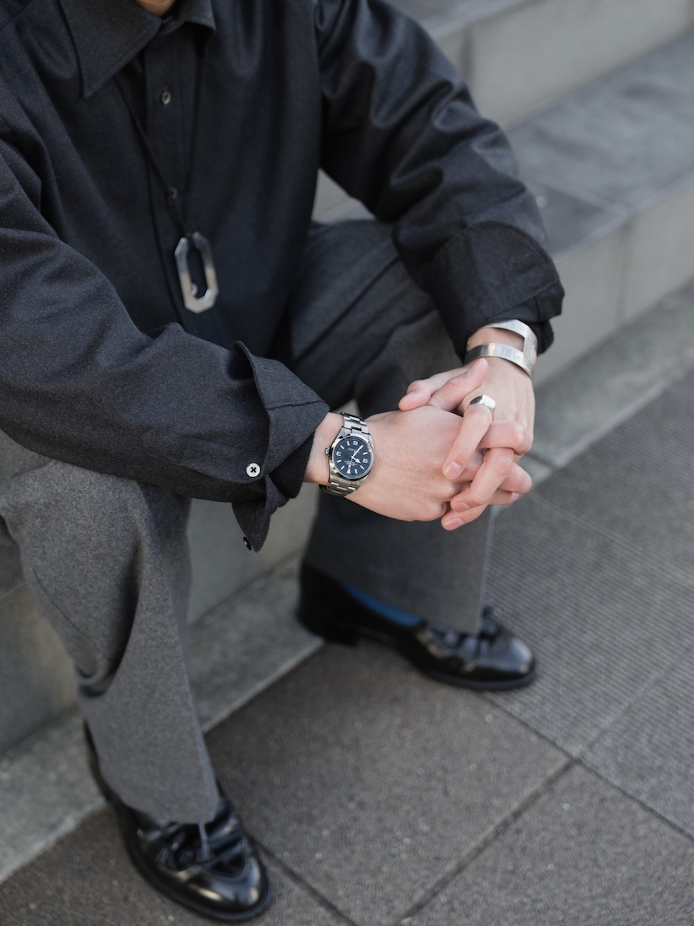 グレー系のシャツ/ブラウス、グレー系のスラックス、ブラック系のローファーを着用したメンズの冬コーディネートの4枚目の写真