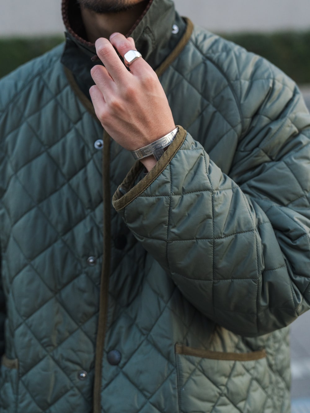 グリーン系のダウンジャケット/コート、ブルー系のデニムパンツ、ブラック系のローファーを着用したメンズの秋コーディネートの2枚目の写真