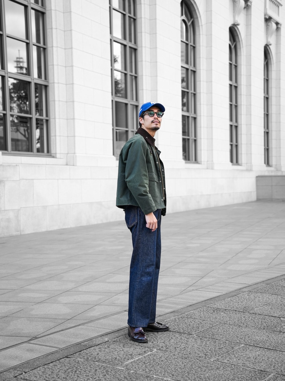 グリーン系のブルゾン、ブルー系のデニムパンツ、ブラウン系のドレスシューズを着用したメンズの春コーディネートの3枚目の写真