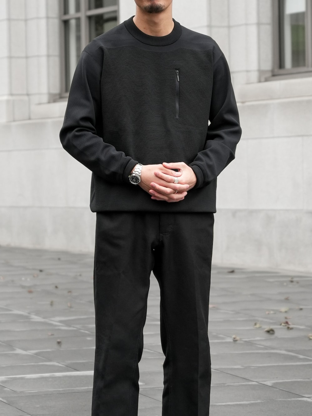 ブラック系のトップス、ブラック系のチノパンツ、ブラック系のスニーカーを着用したメンズの秋コーディネートの4枚目の写真