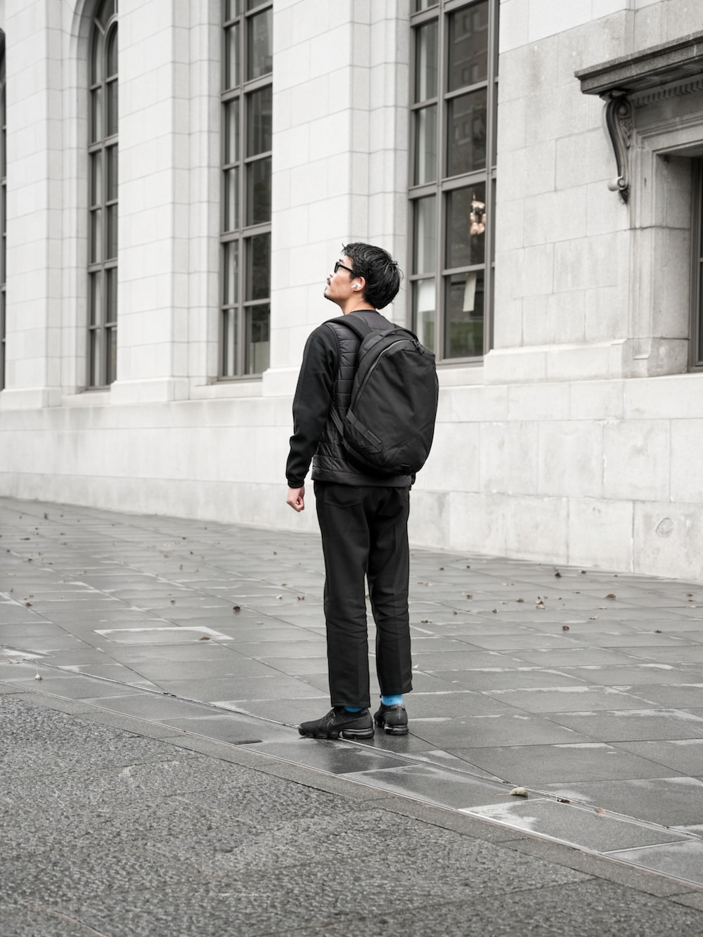 ブラック系のトップス、ブラック系のチノパンツ、ブラック系のスニーカーを着用したメンズの秋コーディネートの2枚目の写真