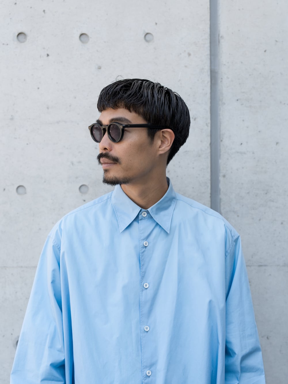 ブルー系のデニムパンツ、ホワイト系のスニーカー、ブルー系のシャツ/ブラウスを着用したメンズの春コーディネートの3枚目の写真