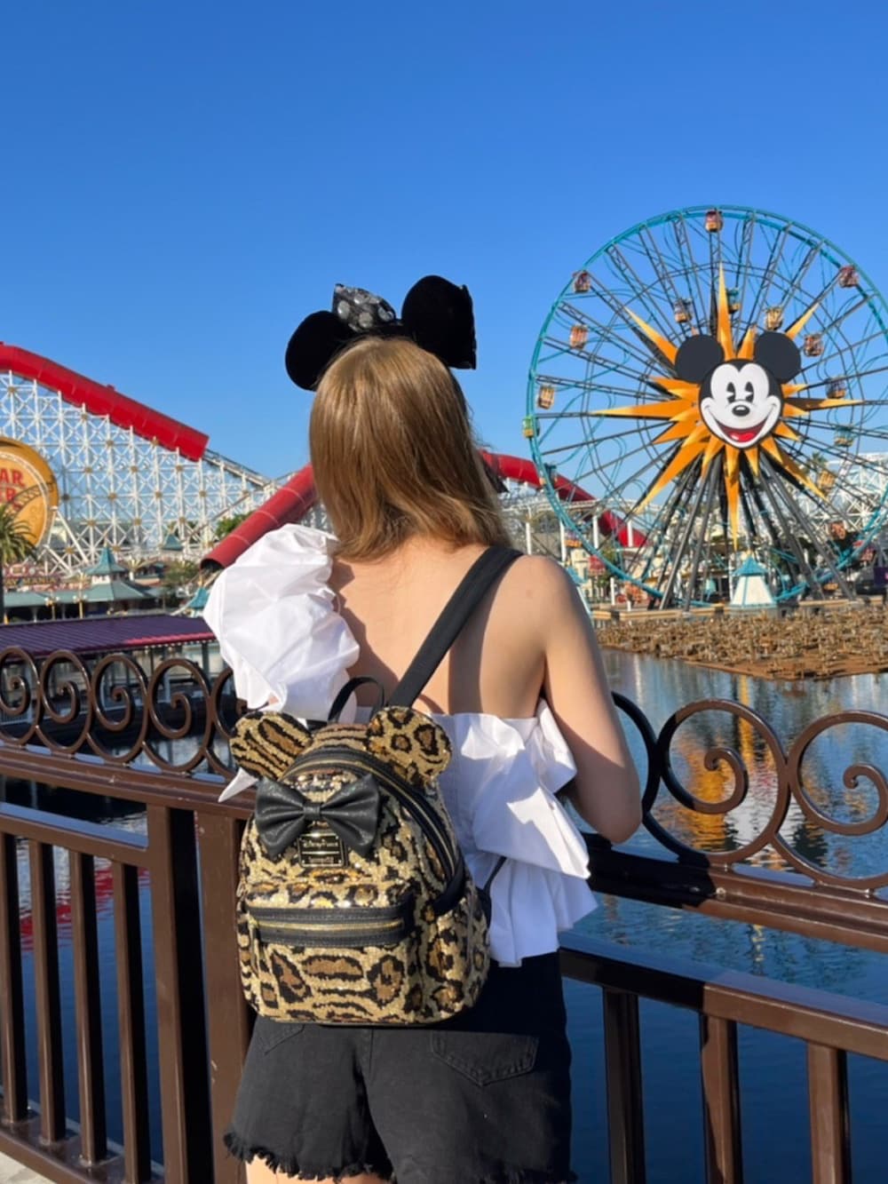 ホワイト系のトップス、ブラック系のデニムパンツ、ホワイト系のショルダーバッグを着用したレディースの秋コーディネートの2枚目の写真