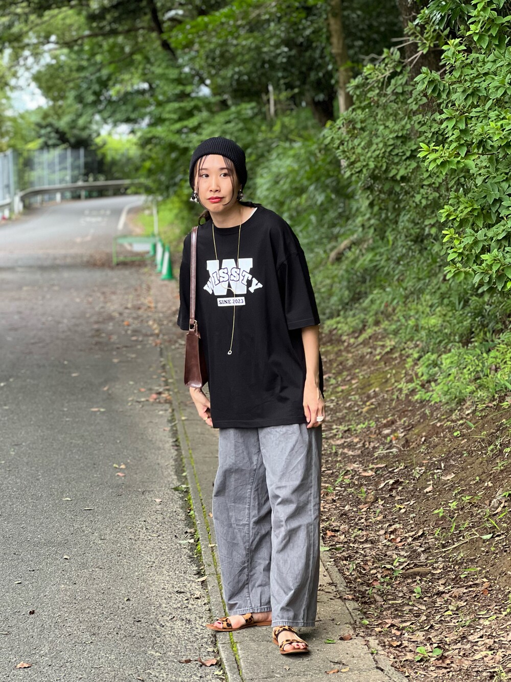 ブラック系のTシャツ/カットソー、グレー系のデニムパンツ、ブラウン系のショルダーバッグを着用したレディースの夏コーディネートの5枚目の写真