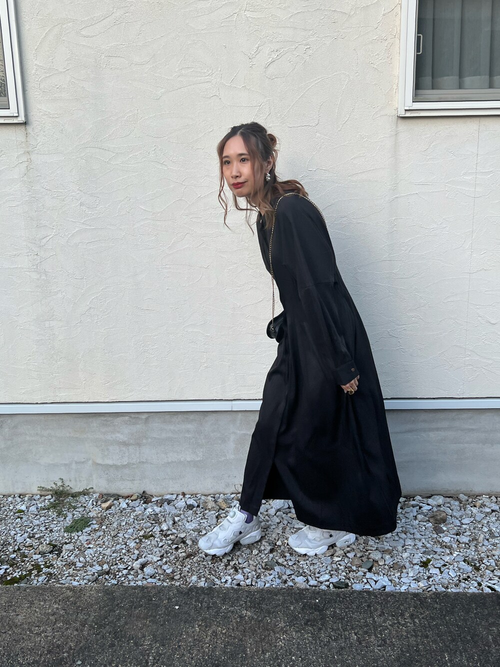 ブラック系のワンピース、ホワイト系のベスト、グレー系のスニーカーを着用したレディースの秋コーディネートの4枚目の写真