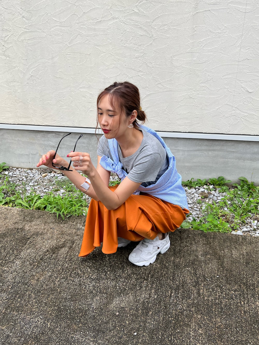 イエロー系のスカート、ブルー系のシャツ/ブラウス、グレー系のスニーカーを着用したレディースの夏コーディネートの3枚目の写真