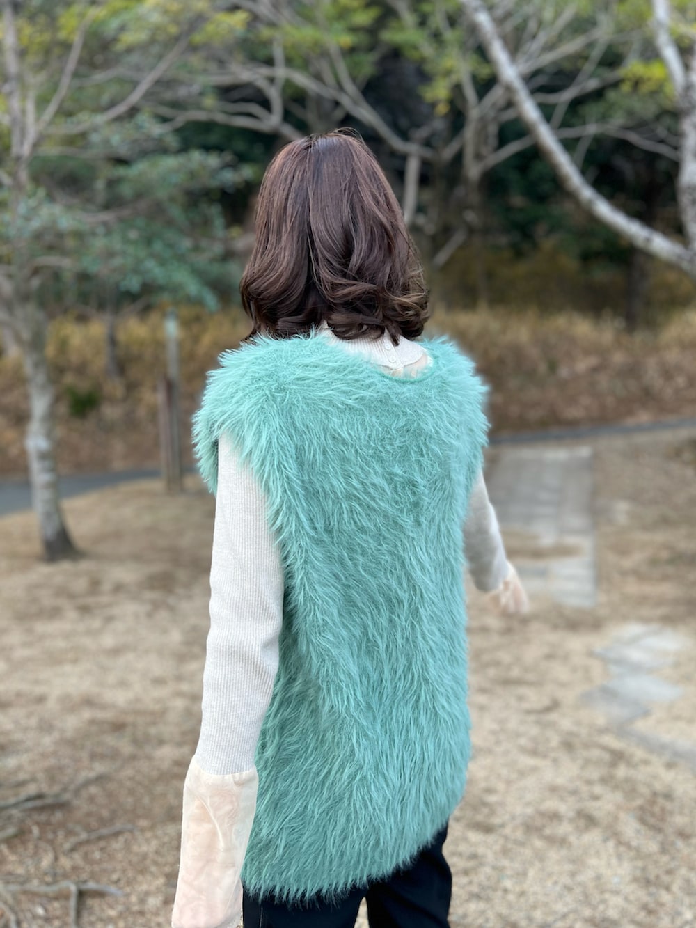 グリーン系のニット/セーター、ベージュ系のニット/セーター、ブラック系のボストンバッグを着用したレディースの冬コーディネートの3枚目の写真