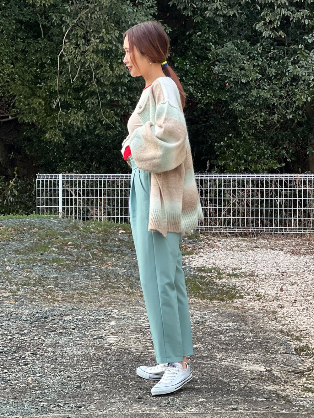 グリーン系のその他パンツ、レッド系のTシャツ/カットソー、グリーン系のカーディガン/ボレロを着用したレディースの冬コーディネートの3枚目の写真