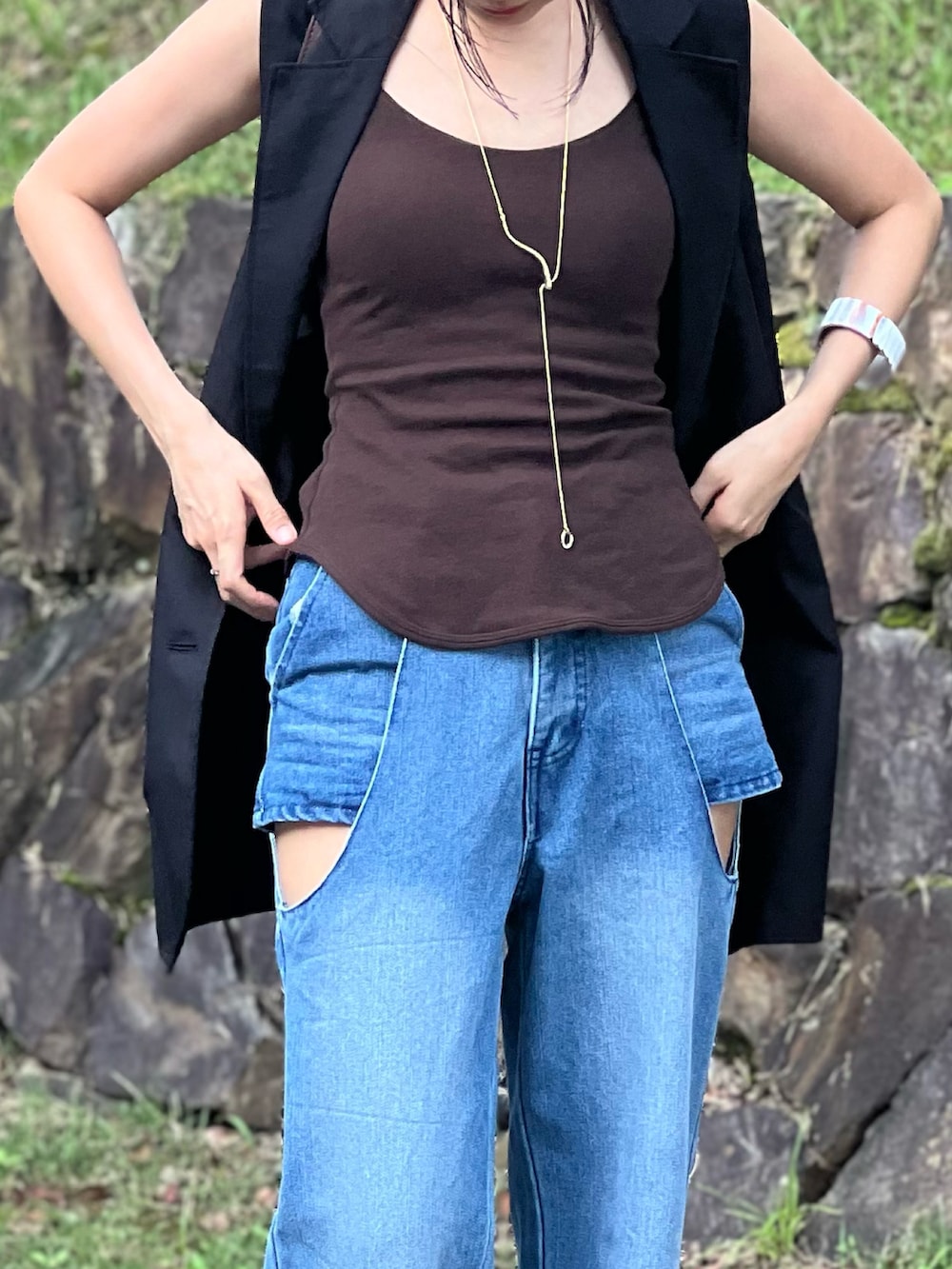 ブルー系のデニムパンツ、ブラウン系のショルダーバッグ、ブラック系のブーツを着用したレディースの夏コーディネートの2枚目の写真