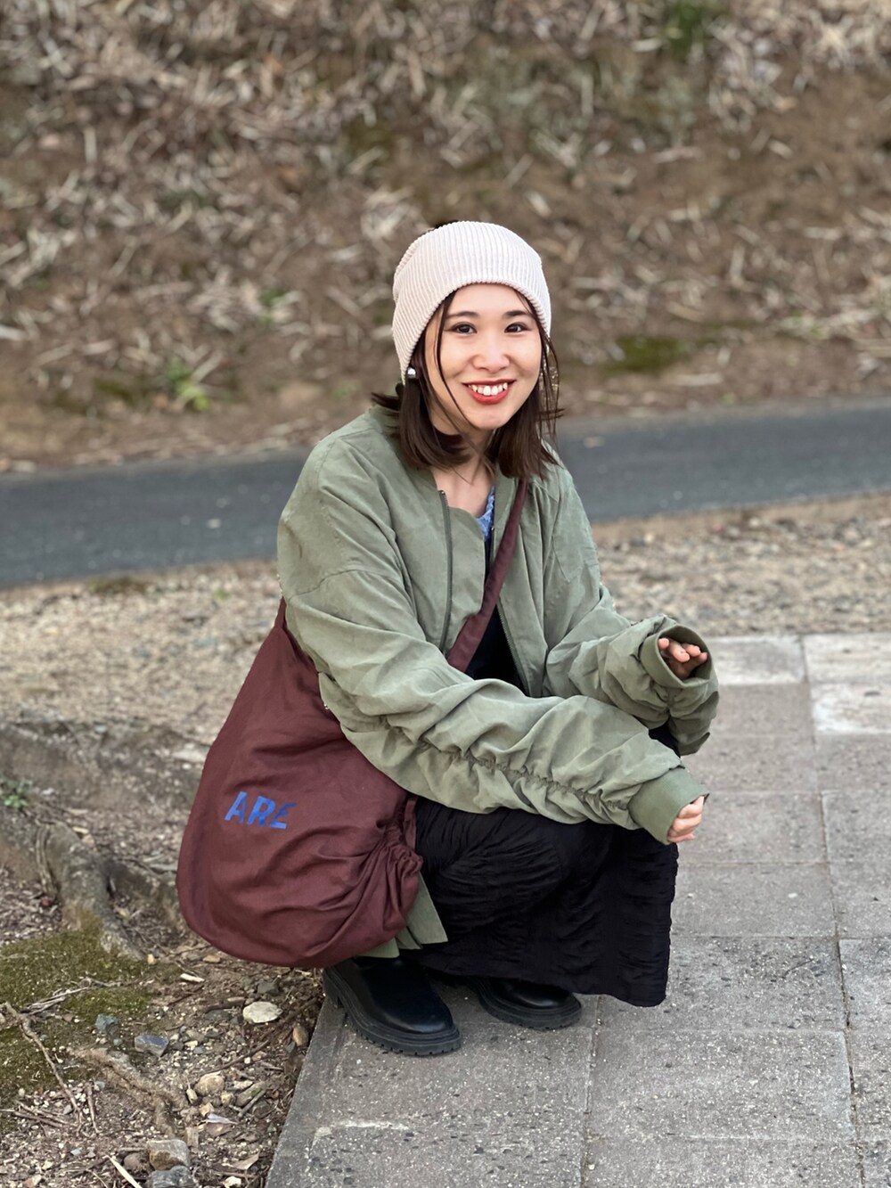 グリーン系のMA-1、ブラック系のキャミソール、ブラック系のスカートを着用したレディースの春コーディネートの2枚目の写真