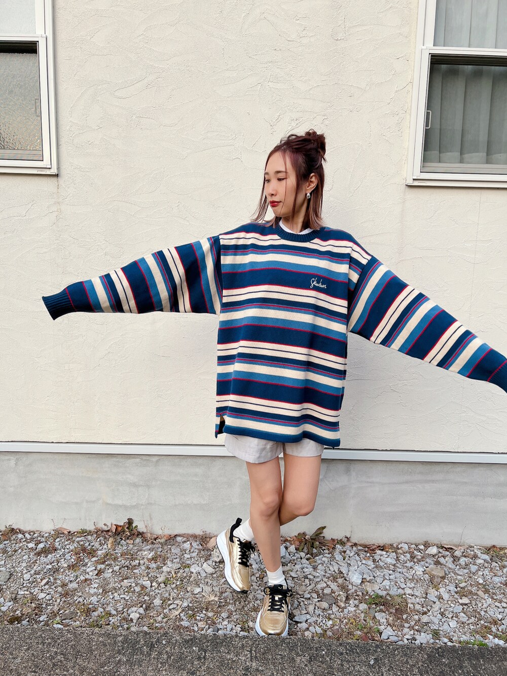 ブルー系のニット/セーター、ゴールド系のスニーカー、シルバー系のリングを着用したレディースの冬コーディネートの5枚目の写真