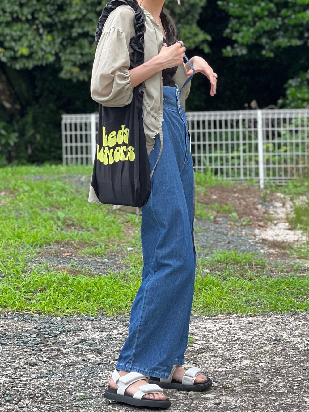 ブルー系のサロペット/オーバーオール、ブラック系のトートバッグ、ホワイト系のサンダルを着用したレディースの夏コーディネートの4枚目の写真