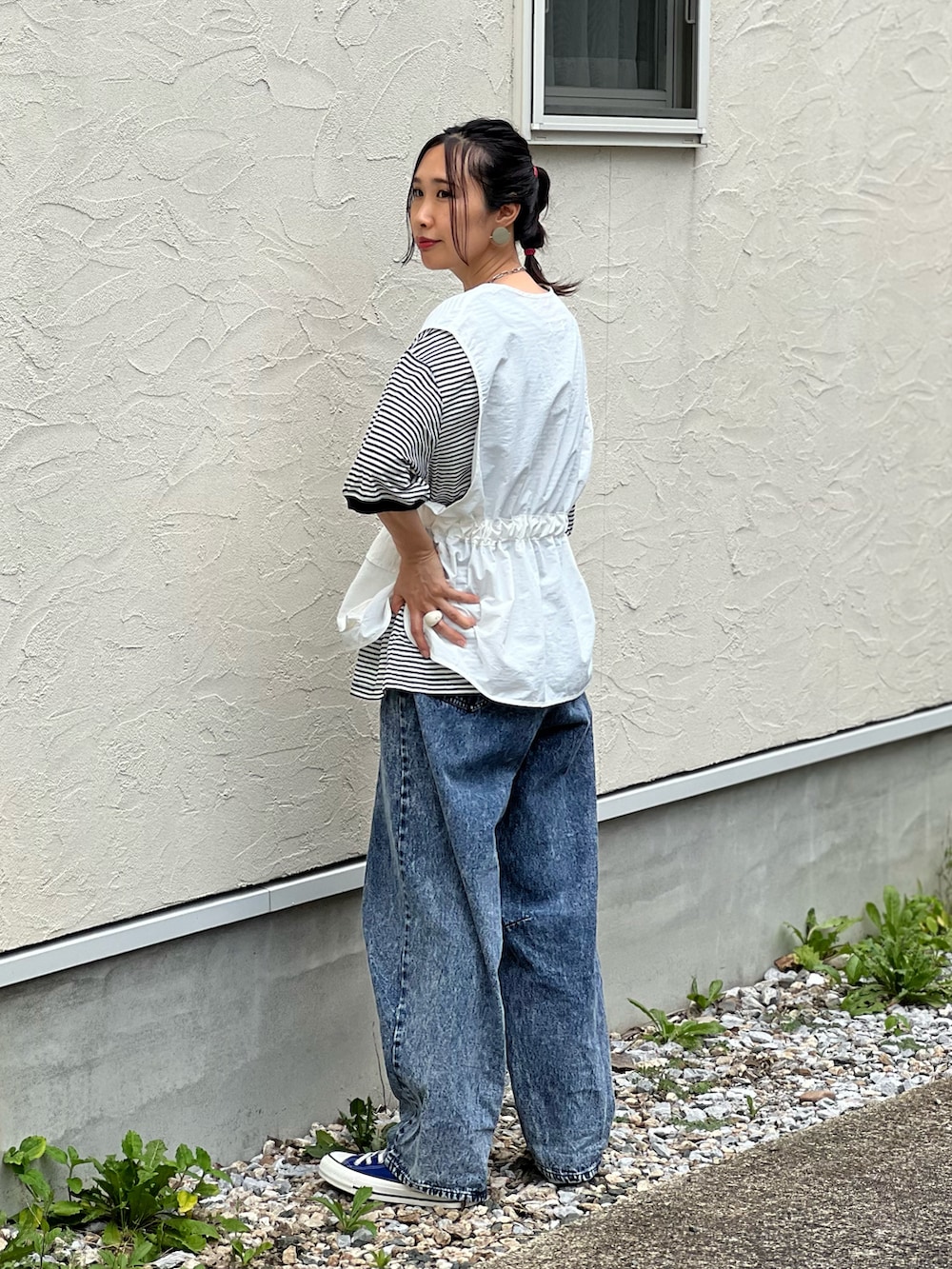 ブラック系のTシャツ/カットソー、ホワイト系のベスト、ブルー系のデニムパンツを着用したレディースの夏コーディネートの2枚目の写真