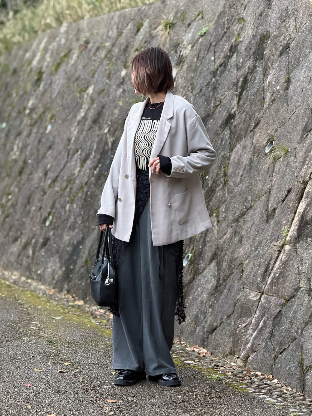 ベージュ系のテーラードジャケット、ブラック系のTシャツ/カットソー、ブラック系のボストンバッグを着用したレディースの春コーディネートの4枚目の写真