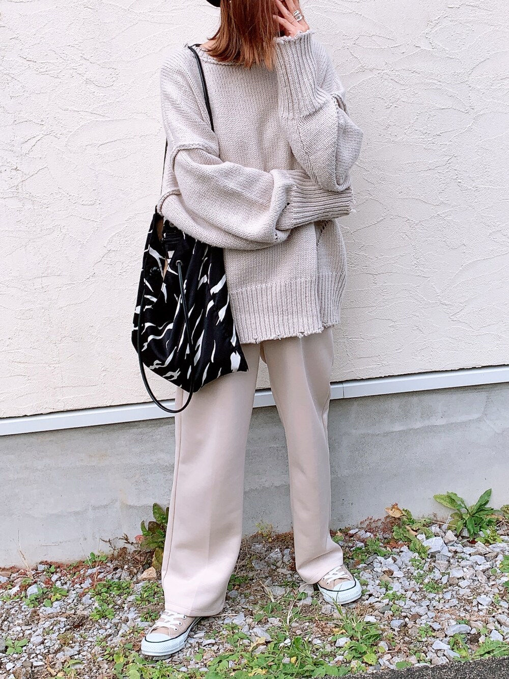 グレー系のニット/セーター、ホワイト系のスラックス、ベージュ系のスニーカーを着用したレディースの秋コーディネートの3枚目の写真