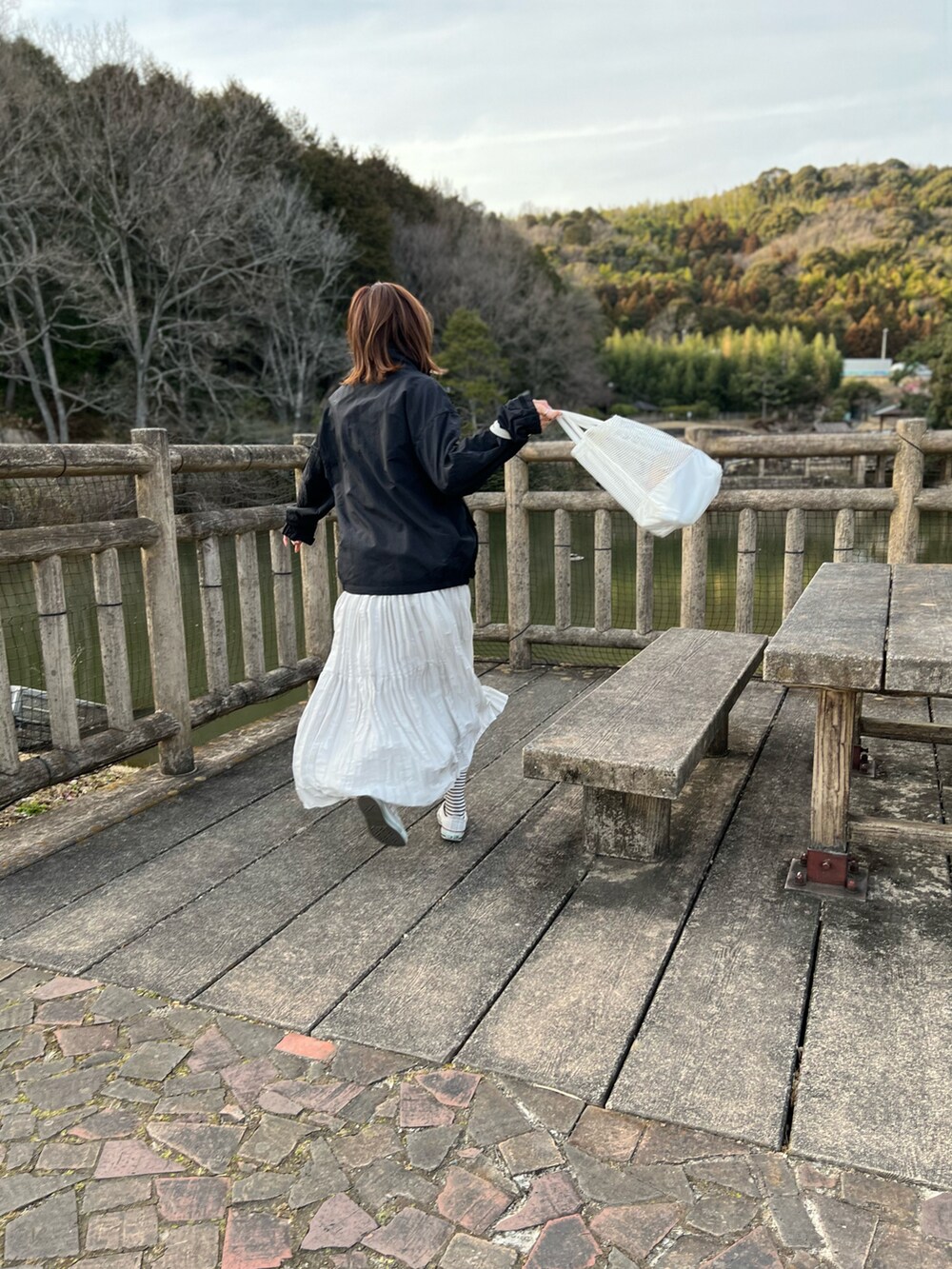 ブラック系のブルゾン、グレー系のスカート、ホワイト系のスニーカーを着用したレディースの春コーディネートの2枚目の写真