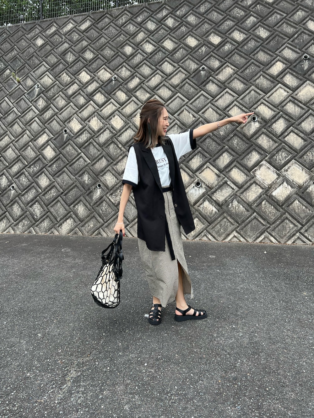 ブラック系のTシャツ/カットソー、ベージュ系のスカート、ブラック系のサンダルを着用したレディースの夏コーディネートの3枚目の写真