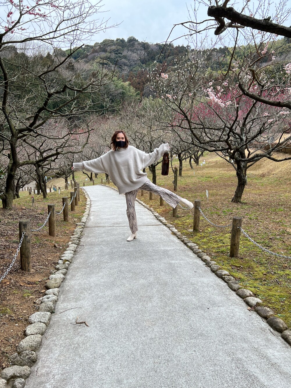 グレー系のニット/セーター、ホワイト系のブーツ、ブラウン系のトートバッグを着用したレディースの春コーディネートの4枚目の写真