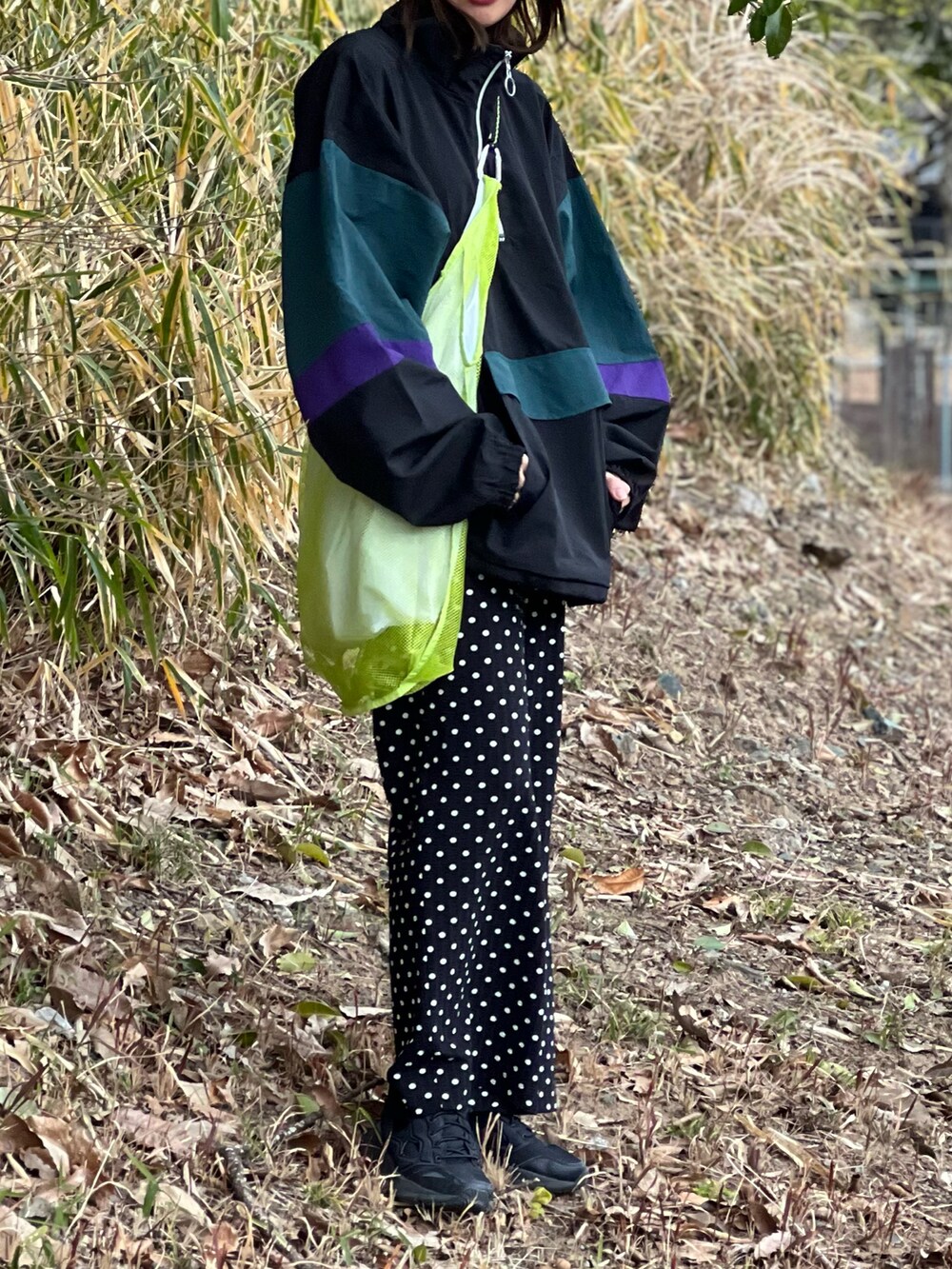 ブラック系のナイロンジャケット、ブラック系のその他パンツ、ブラック系のスニーカーを着用したレディースの春コーディネートの4枚目の写真