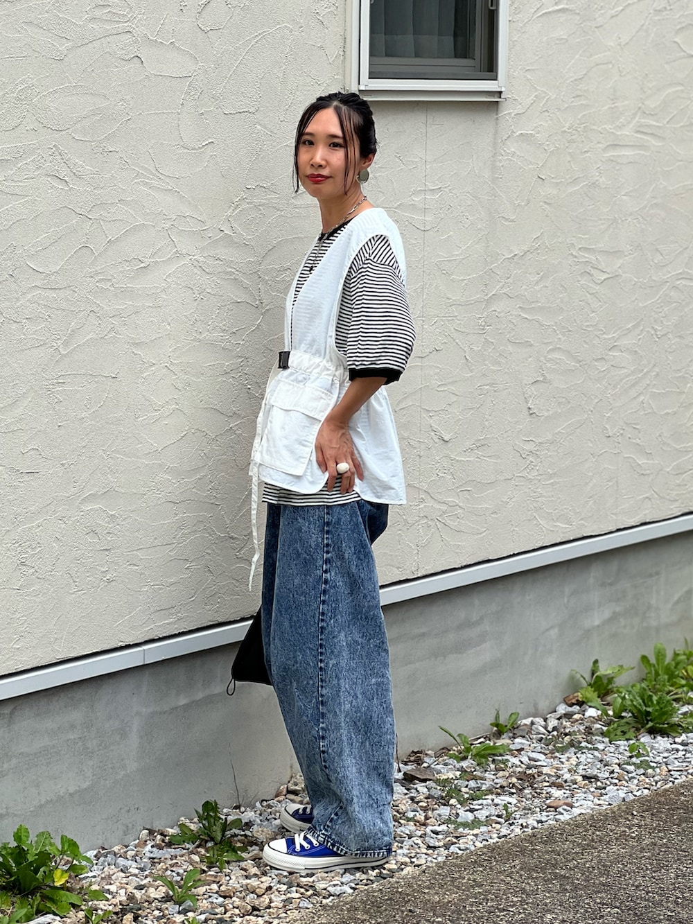 ブラック系のTシャツ/カットソー、ホワイト系のベスト、ブルー系のデニムパンツを着用したレディースの夏コーディネートの4枚目の写真