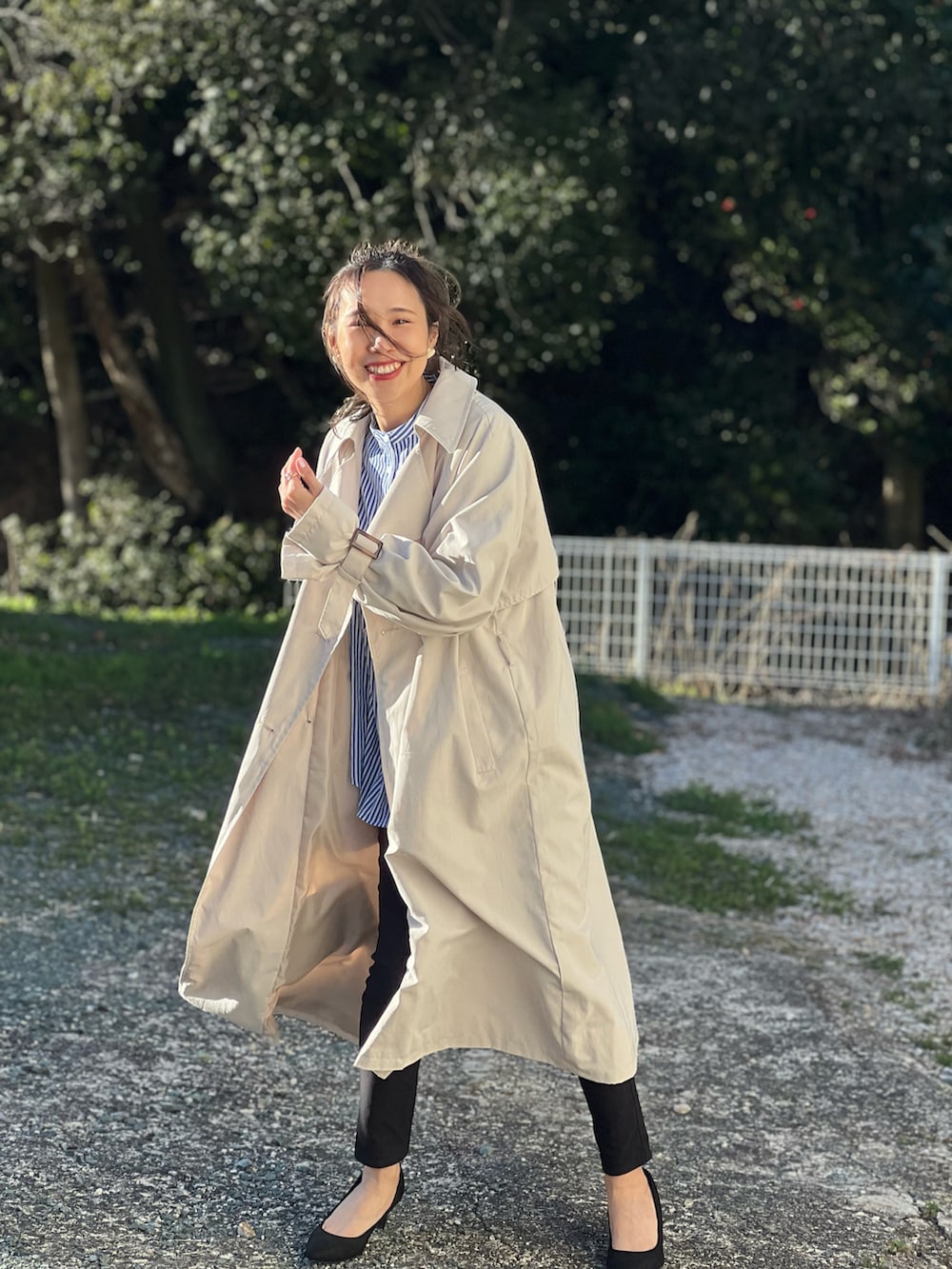 ベージュ系のトレンチコート、ブルー系のシャツ/ブラウス、ブラック系のその他パンツを着用したレディースの春コーディネートの3枚目の写真