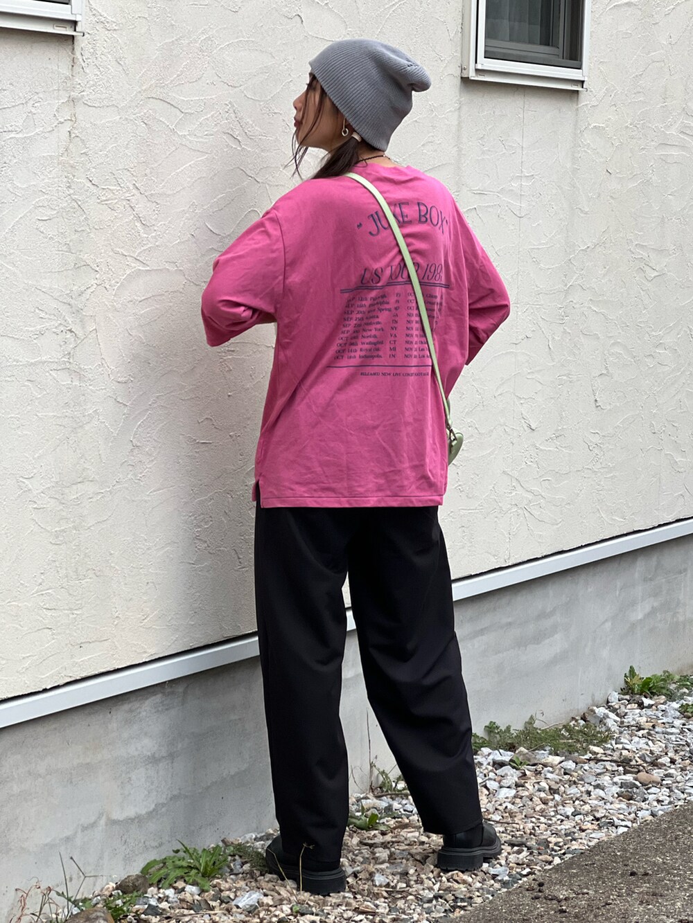 ピンク系のTシャツ/カットソー、ブラック系のスラックス、グリーン系のショルダーバッグを着用したレディースの秋コーディネートの2枚目の写真