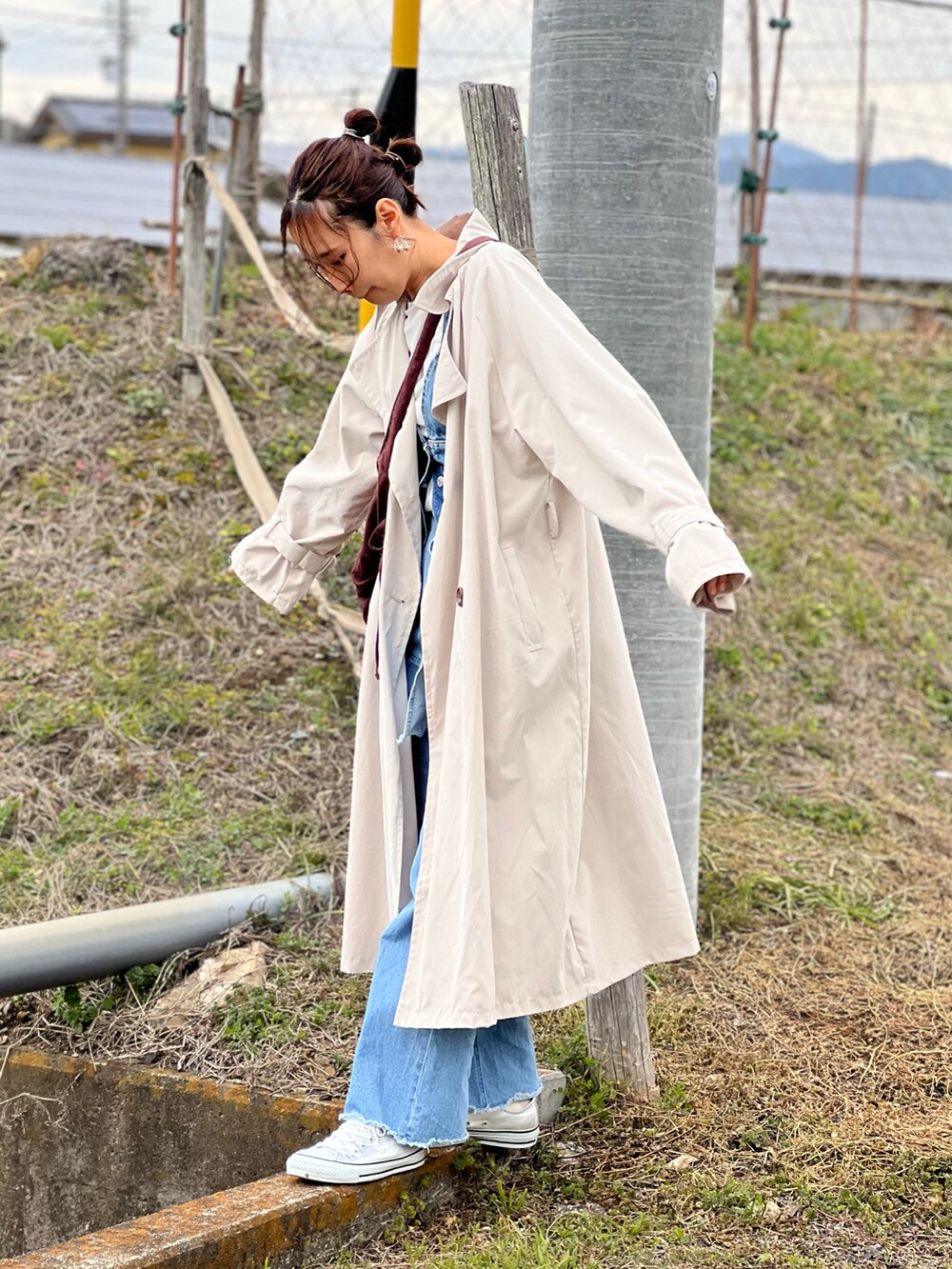 ベージュ系のトレンチコート、ホワイト系のTシャツ/カットソー、ブルー系のその他トップスを着用したレディースの春コーディネートの4枚目の写真