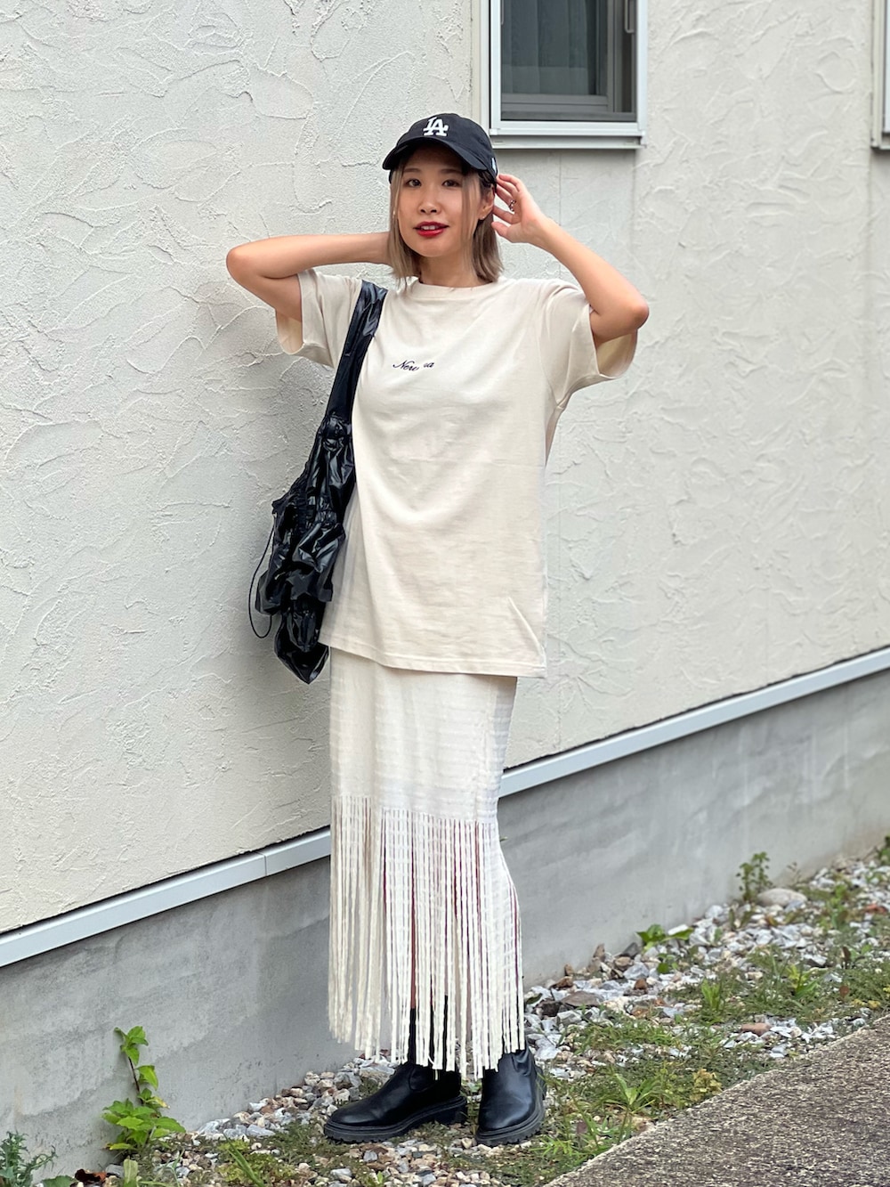 ベージュ系のTシャツ/カットソー、ブラック系のトートバッグ、ホワイト系のスカートを着用したレディースの夏コーディネートの4枚目の写真