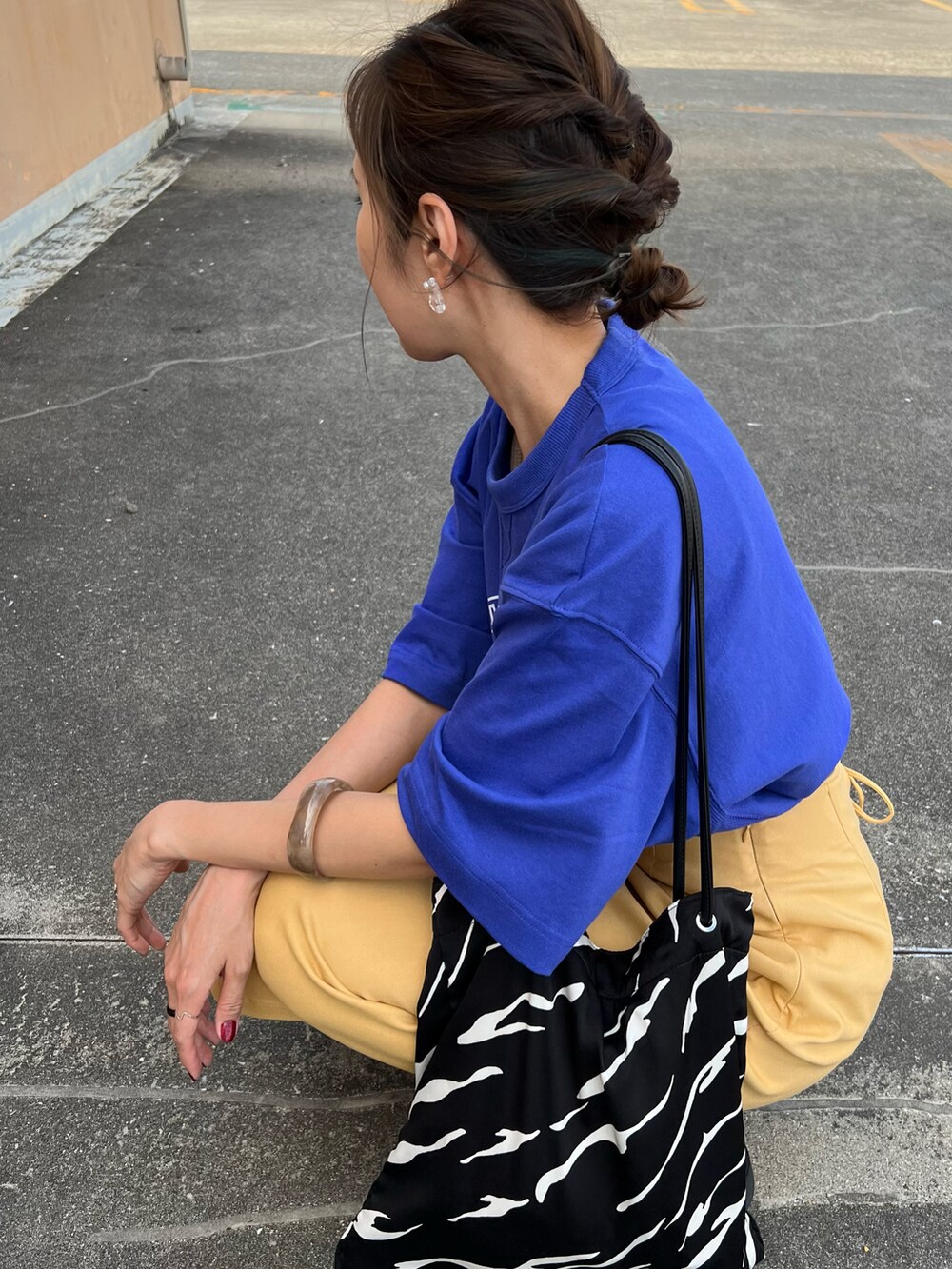 ブルー系のTシャツ/カットソー、イエロー系のスカート、ブラック系のサンダルを着用したレディースの夏コーディネートの5枚目の写真