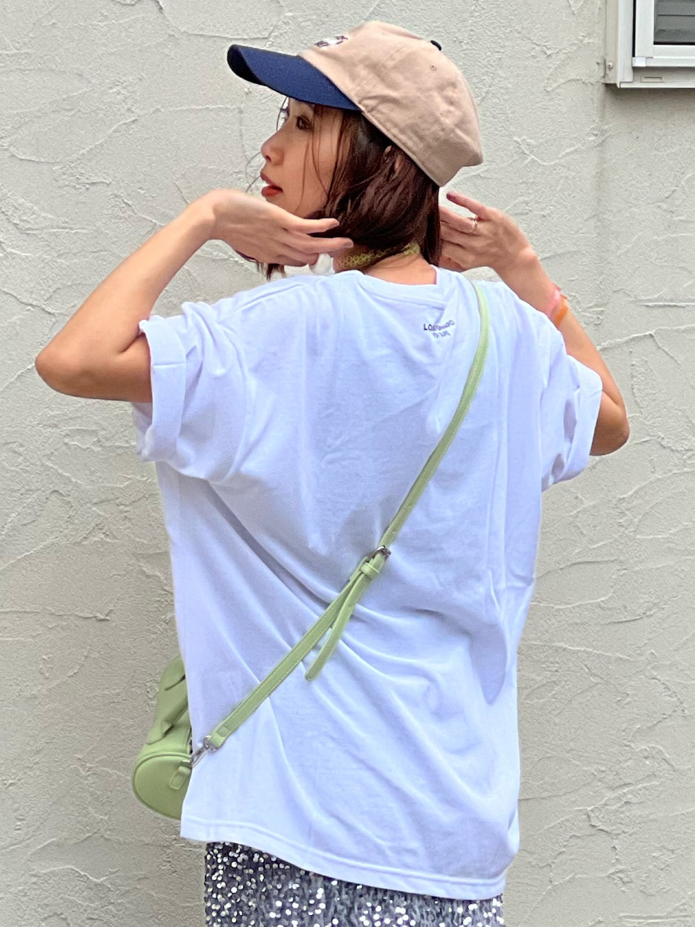 ホワイト系のTシャツ/カットソー、シルバー系のスカート、グリーン系のショルダーバッグを着用したレディースの春コーディネートの3枚目の写真