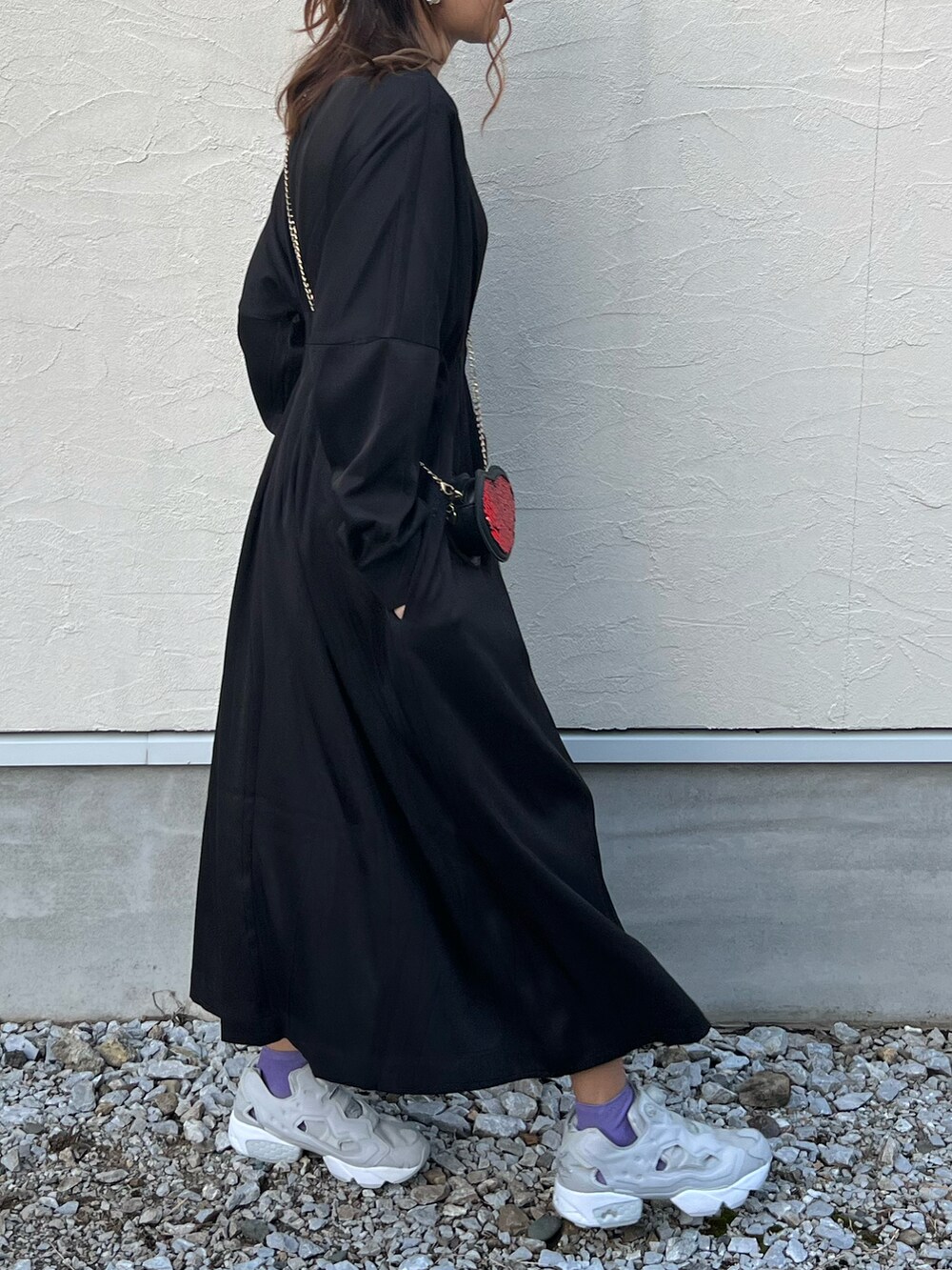 ブラック系のワンピース、ホワイト系のベスト、グレー系のスニーカーを着用したレディースの秋コーディネートの2枚目の写真