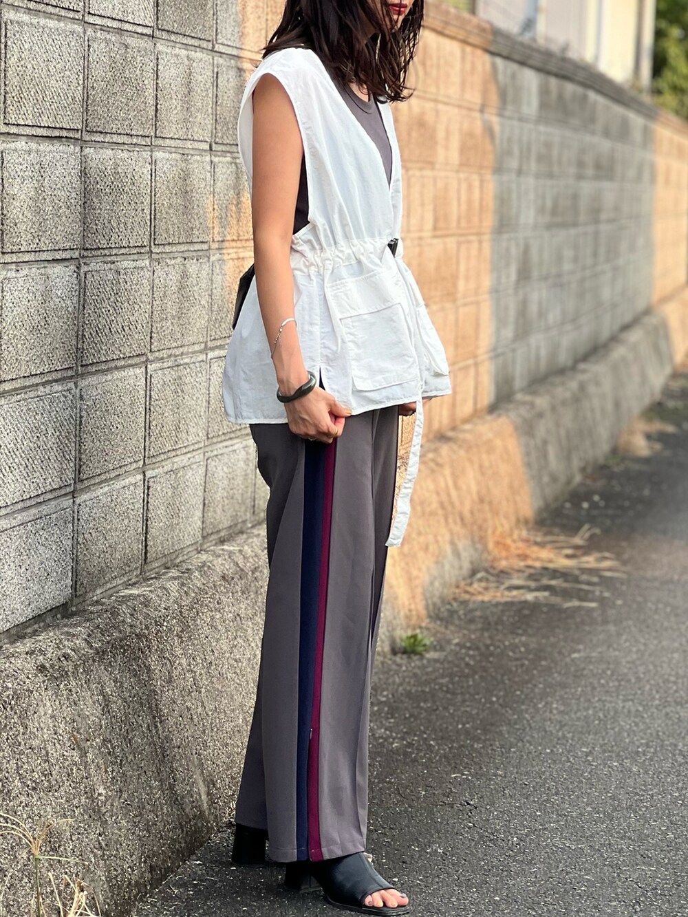 ホワイト系のベスト、グレー系のタンクトップ、グレー系のその他パンツを着用したレディースの夏コーディネートの4枚目の写真