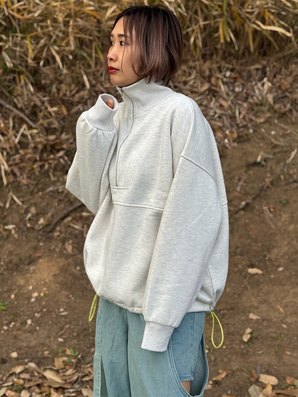 ベージュ系のスウェット、グレー系のTシャツ/カットソー、ブルー系のデニムパンツを着用したレディースの冬コーディネートの3枚目の写真