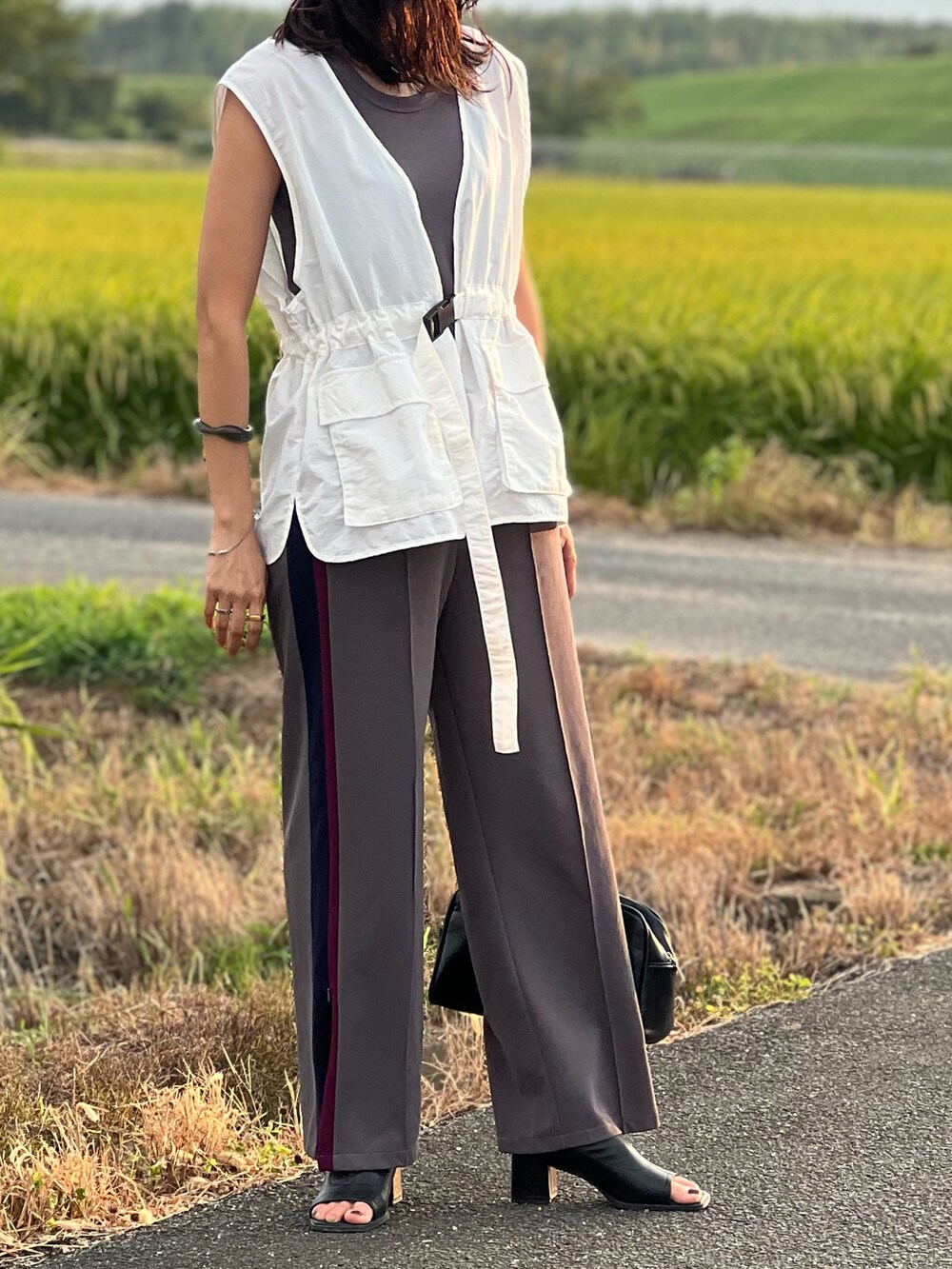 ホワイト系のベスト、グレー系のタンクトップ、グレー系のその他パンツを着用したレディースの夏コーディネートの2枚目の写真