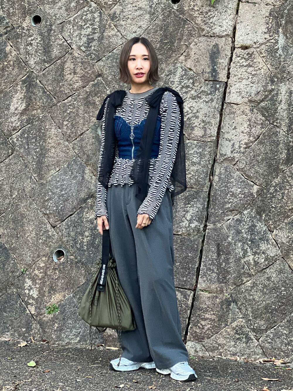 ブラック系のニット/セーター、ブルー系のその他トップス、グレー系のパンツを着用したレディースの冬コーディネートの2枚目の写真