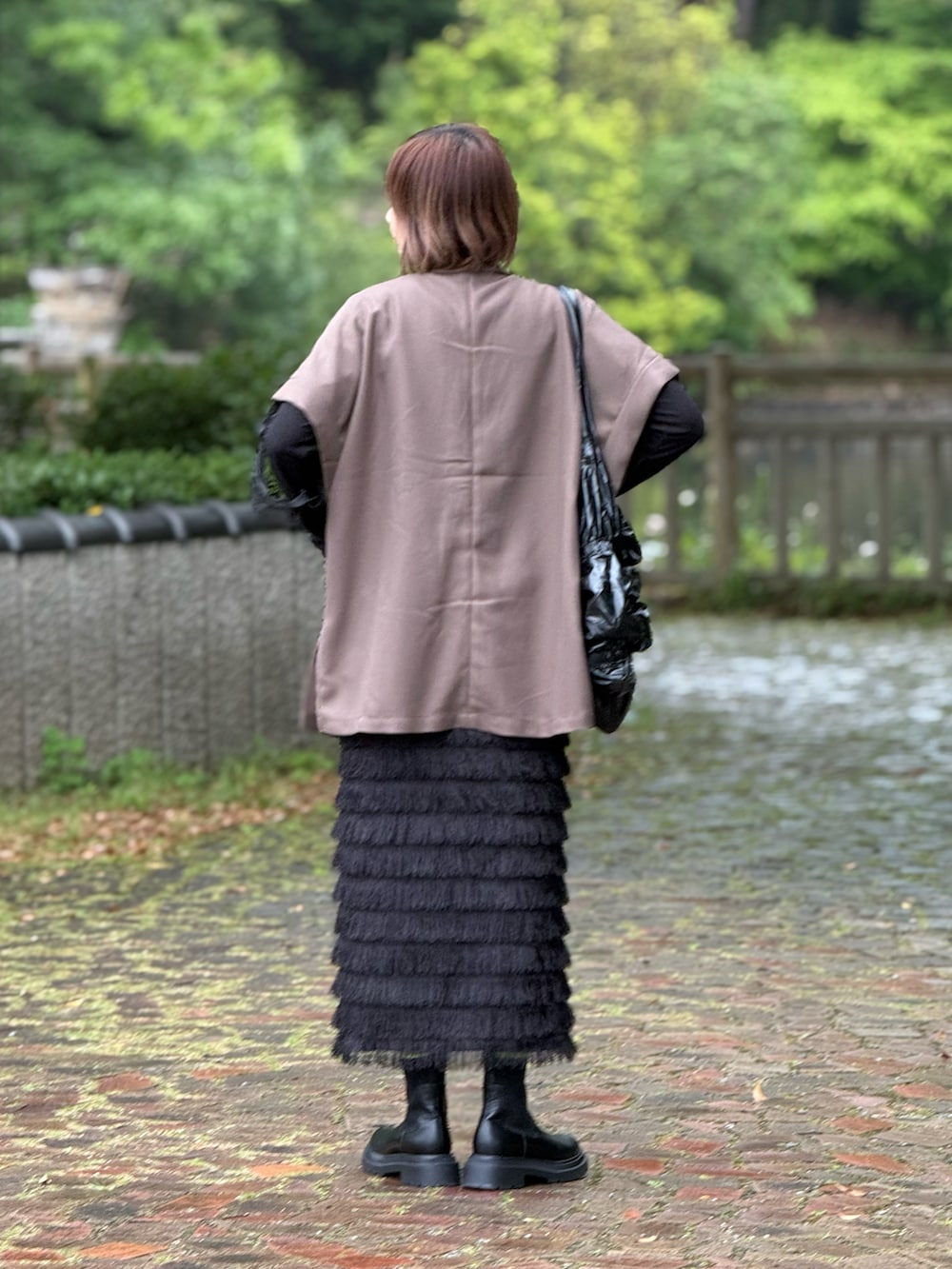 ブラウン系のテーラードジャケット、ブラック系のトートバッグ、ブラック系のTシャツ/カットソーを着用したレディースの春コーディネートの3枚目の写真