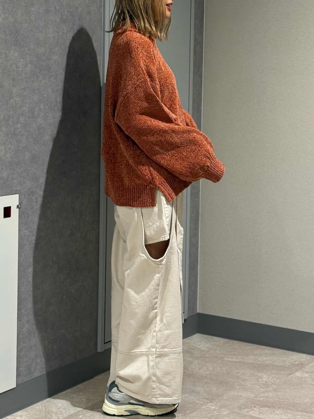 ブラウン系のニット/セーター、ホワイト系のデニムパンツ、グレー系のスニーカーを着用したレディースの秋コーディネートの3枚目の写真