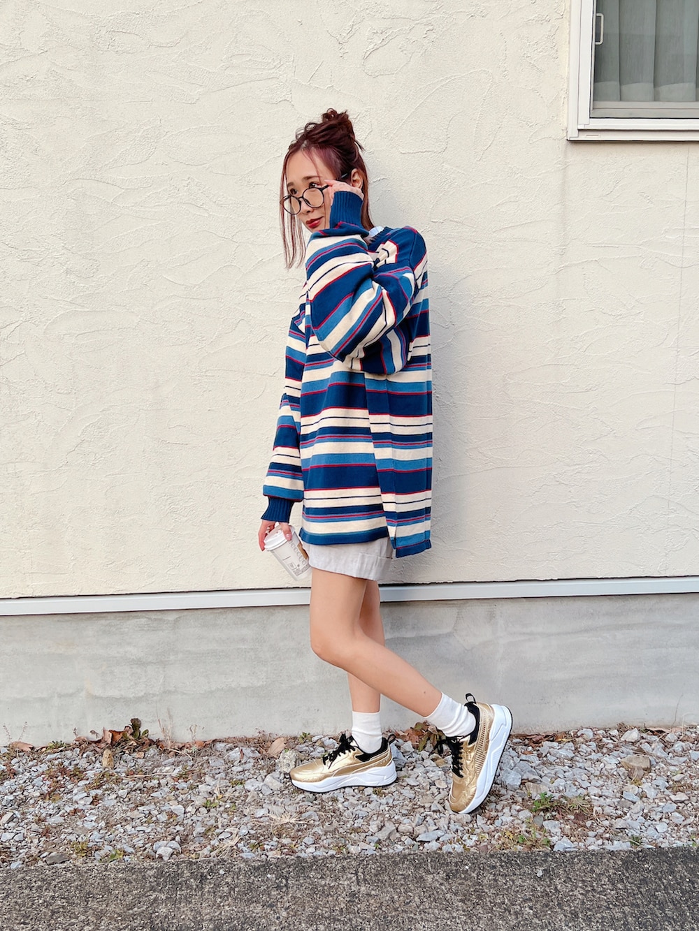 ブルー系のニット/セーター、ゴールド系のスニーカー、シルバー系のリングを着用したレディースの冬コーディネートの2枚目の写真