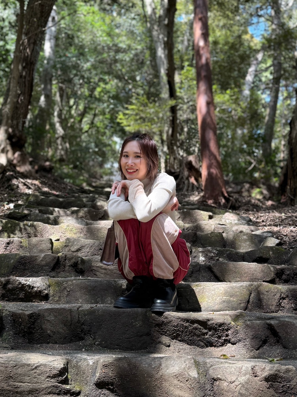 ブラウン系のショルダーバッグ、ベージュ系のニット/セーター、レッド系のその他パンツを着用したレディースの春コーディネートの3枚目の写真