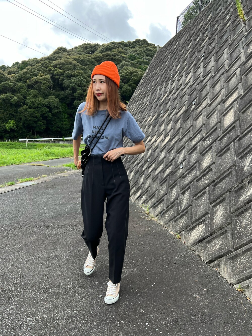 ブルー系のTシャツ/カットソー、ブラック系のパンツ、ベージュ系のスニーカーを着用したレディースの秋コーディネートの5枚目の写真