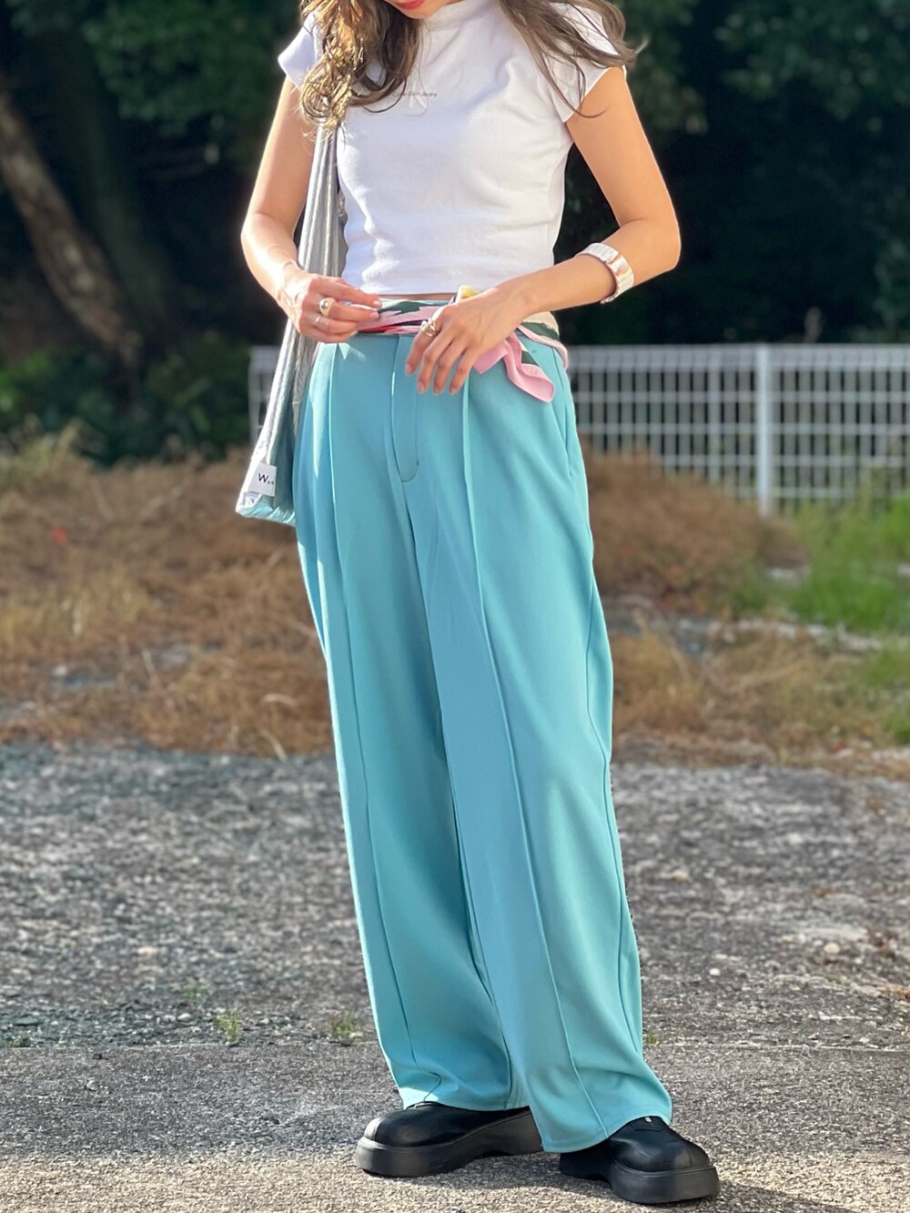 ホワイト系のTシャツ/カットソー、ブルー系のパンツ、ブラック系のブーツを着用したレディースの春コーディネートの4枚目の写真