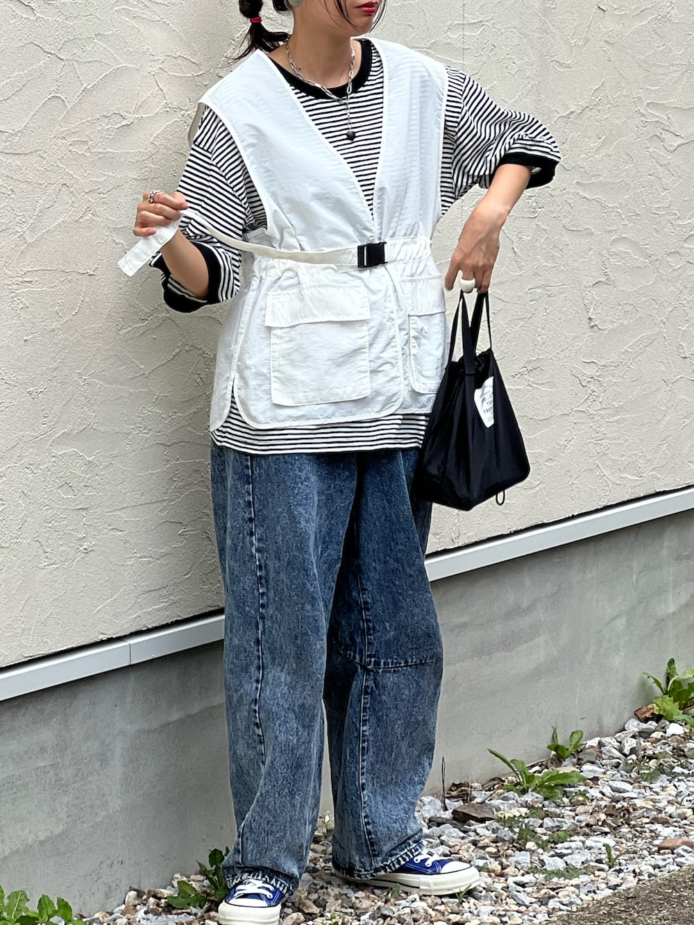 ブラック系のTシャツ/カットソー、ホワイト系のベスト、ブルー系のデニムパンツを着用したレディースの夏コーディネートの3枚目の写真