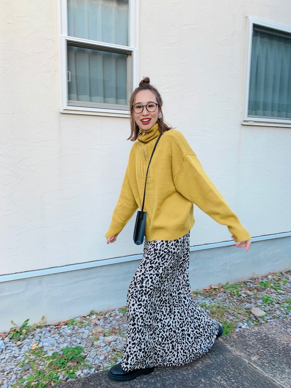 イエロー系のニット/セーター、ベージュ系のスカート、ブラック系のトートバッグを着用したレディースの冬コーディネートの5枚目の写真