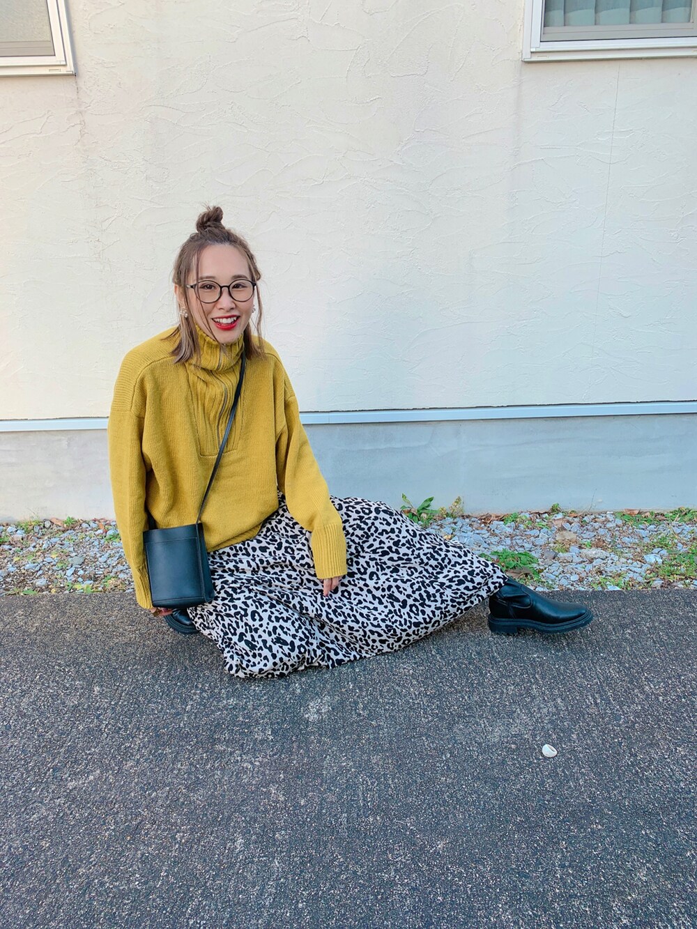 イエロー系のニット/セーター、ベージュ系のスカート、ブラック系のトートバッグを着用したレディースの冬コーディネートの4枚目の写真